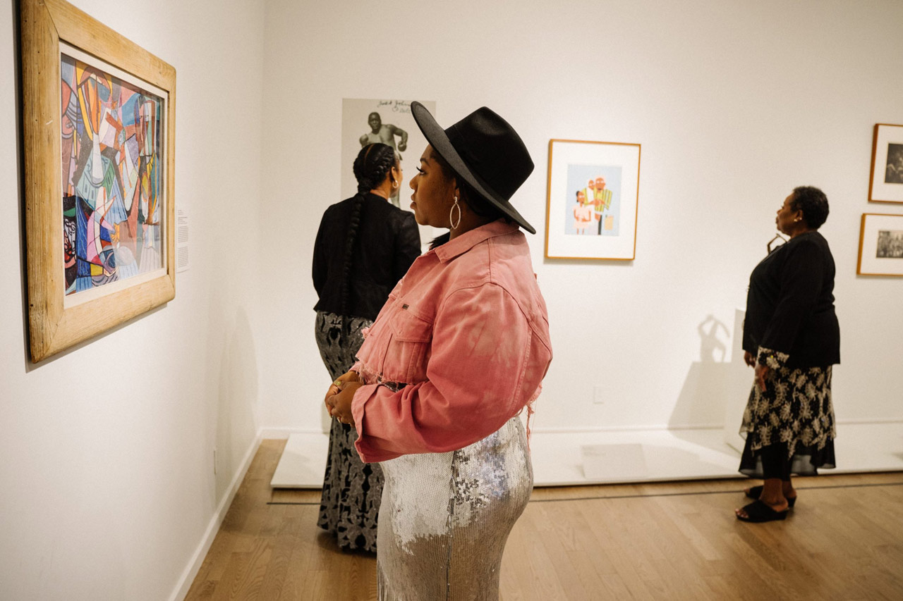 Visitors looking at paintings in gallery